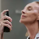 Mujer aplicando bruma facial para que sirve: refrescar e hidratar la piel.