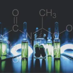Ampollas con líquido verde y una botella con cápsulas, sobre un fondo oscuro con fórmulas químicas. Descubre qué son los péptidos en cosmética.