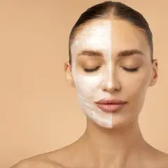 Una mujer con la mitad de la cara cubierta de espuma, mostrando la efectividad de que es la doble limpieza facial para una piel radiante.
