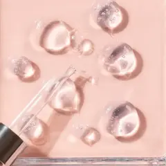 Gotas de sérum con glicerina para que sirve, humectando la piel. Pipeta de cristal sobre fondo rosa.