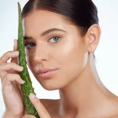 Mujer con hoja de aloe vera, mostrando cómo el aloe vera para que sirve para una piel radiante y saludable.