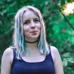 Chica con cabello teñido de azul y plateado, con piercing en la nariz. ¿Buscas como quitar el verde del pelo?