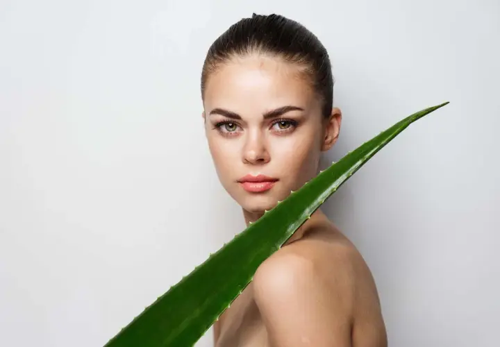 Mujer con un gran trozo de aloe vera. El aloe vera es bueno para el pelo, aportando brillo y fuerza.