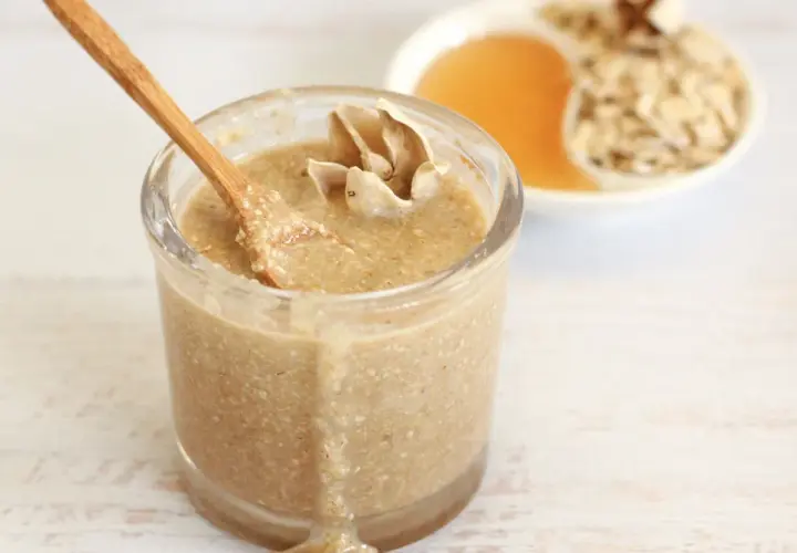 Un tarro de exfoliante facial casero con avena y miel, listo para una piel radiante.