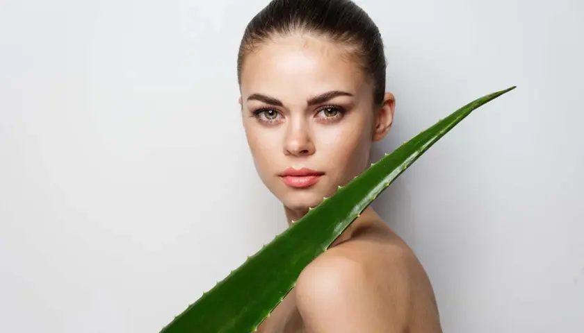 Mujer con un gran trozo de aloe vera. El aloe vera es bueno para el pelo, aportando brillo y fuerza.