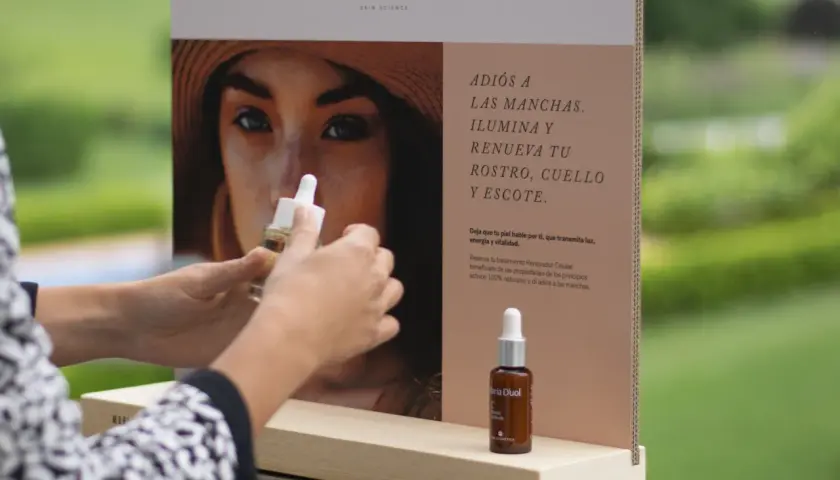 Manos sostienen un frasco de serum de vitamina C, ideal para combatir las manchas que la vitamina C mancha la piel con el sol.