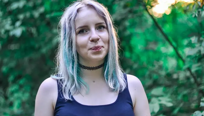 Chica con cabello teñido de azul y plateado, con piercing en la nariz. ¿Buscas como quitar el verde del pelo?
