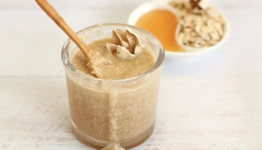 Un tarro de exfoliante facial casero con avena y miel, listo para una piel radiante.