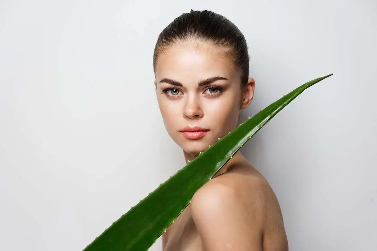 Mujer con un gran trozo de aloe vera. El aloe vera es bueno para el pelo, aportando brillo y fuerza.