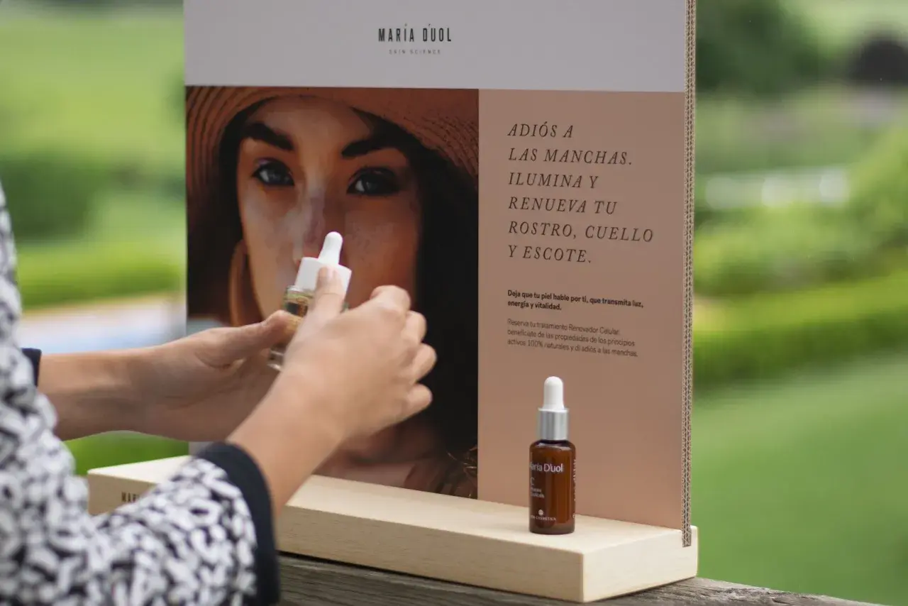 Manos sostienen un frasco de serum de vitamina C, ideal para combatir las manchas que la vitamina C mancha la piel con el sol.
