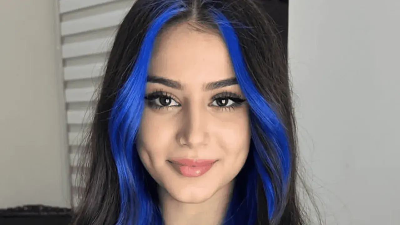 Chica con cabello oscuro y mechas money piece de color azul vibrante.