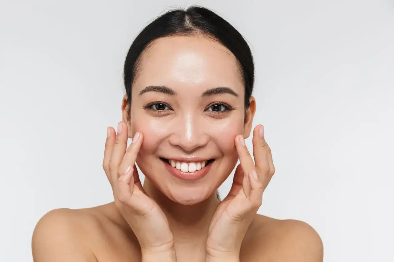 Mujer sonriente con piel radiante, explorando los beneficios de la coenzima q10 para que sirve en mujeres.