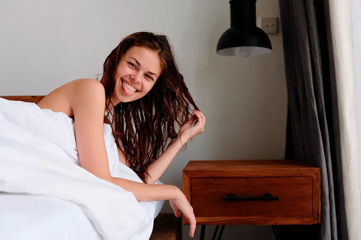 Joven sonríe con pelo mojado, ¡quizás no sea bueno dormir así!